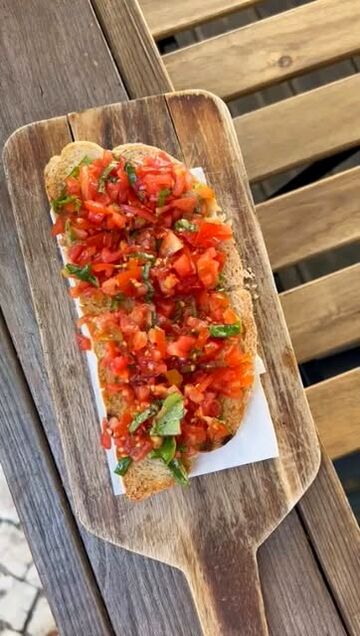 Bruschetta com tomate picado e manjericão numa tábua de madeira